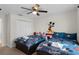 Mickey Mouse themed bedroom with two twin beds, dresser, and ceiling fan at 1224 Challenge Dr, Davenport, FL 33896