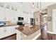 Island kitchen with granite countertops, white cabinets and stainless steel appliances at 801 Lobelia Dr, Lake Mary, FL 32746