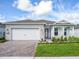 One-story home with white siding, stone accents, and a two-car garage at 2476 Pine Preserve Ct, St Cloud, FL 34771