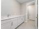Modern laundry room with white cabinets and countertop at 2476 Pine Preserve Ct, St Cloud, FL 34771
