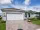 Two-car garage with paver driveway and landscaping at 2476 Pine Preserve Ct, St Cloud, FL 34771
