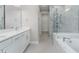 Elegant bathroom featuring double vanity, soaking tub, and a frameless shower at 2476 Pine Preserve Ct, St Cloud, FL 34771