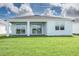 Rear view of a house with a covered patio and grassy lawn at 2476 Pine Preserve Ct, St Cloud, FL 34771