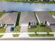 Three homes with garages and landscaping next to a lake at 2476 Pine Preserve Ct, St Cloud, FL 34771
