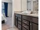 Bathroom with granite countertop, dark brown vanity, and shower at 2031 Lelani Cir, Davenport, FL 33897
