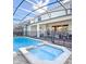 Inviting pool and spa with screened enclosure and patio furniture at 2031 Lelani Cir, Davenport, FL 33897