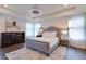 Spacious bedroom with gray upholstered bed, hardwood floors, and large windows at 14007 Creek Harbor Dr, Orlando, FL 32824