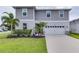 Two-story house with gray siding, white garage door, and landscaping at 14007 Creek Harbor Dr, Orlando, FL 32824