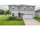 Two-story house with gray siding, white garage door, and landscaping at 14007 Creek Harbor Dr, Orlando, FL 32824