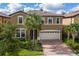Two story house with a large driveway and palm trees at 8804 Macapa Dr, Kissimmee, FL 34747