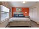 Bedroom with a queen-size bed and an orange accent wall at 8804 Macapa Dr, Kissimmee, FL 34747