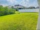 Spacious grassy backyard with a white vinyl fence and a view of the neighboring house at 737 Trillium Ct, Debary, FL 32713