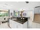 Open kitchen features a large island with granite countertops and stainless steel appliances at 5229 Oakbourne Ave, Davenport, FL 33837