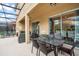 Covered patio with dining table and comfortable seating overlooking the pool at 5229 Oakbourne Ave, Davenport, FL 33837
