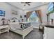 Bright bedroom with a queen-size bed, large window, and neutral decor at 10472 Petrillo Way, Winter Garden, FL 34787