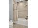 Bathroom with tub shower combination and beige tile at 10472 Petrillo Way, Winter Garden, FL 34787