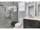 Bathroom with patterned tile shower, dark vanity, and modern fixtures at 10472 Petrillo Way, Winter Garden, FL 34787