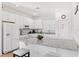 Modern kitchen with white cabinets, granite countertops, and stainless steel appliances at 2654 Rosemont Cir, Davenport, FL 33837