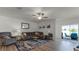 Bright living room features a comfy sectional sofa, large windows, and sliding glass doors to the backyard at 2716 Fieldbrooke Way, Edgewater, FL 32141