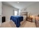 Guest bedroom with blue blanket, wood nightstand, and large window at 1475 Haines Dr, Winter Haven, FL 33881