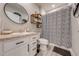 Clean bathroom with patterned shower curtain, white vanity, and built-in shelving at 1475 Haines Dr, Winter Haven, FL 33881