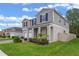 Two-story house with gray siding, white garage door, and landscaped yard at 2864 Sanctuary Dr, Clermont, FL 34714