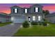 Two-story house with gray siding, white garage door, and landscaped yard at 2864 Sanctuary Dr, Clermont, FL 34714