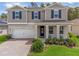 Two-story house with gray siding, white garage door, and landscaped yard at 2864 Sanctuary Dr, Clermont, FL 34714