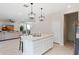 Open kitchen with island, white cabinets, and stainless steel appliances at 2864 Sanctuary Dr, Clermont, FL 34714