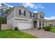 Two-story house with gray siding, white garage door, and a paver driveway at 2864 Sanctuary Dr, Clermont, FL 34714