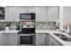 Modern kitchen with gray cabinets, stainless steel appliances, and quartz countertops at 13905 Fairway Island Dr # 1022, Orlando, FL 32837