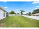 View of a large backyard with green grass and a white fence at 1302 Belmar Ter, Deltona, FL 32725