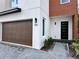 Modern home exterior with brown wood garage door and brick accents at 1919 S Lakemont Ave, Winter Park, FL 32792