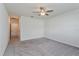 Bright bedroom with ceiling fan and grey carpeting, and access to hallway at 25 Bahia Crse, Ocala, FL 34472