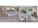 Bright dining room with white table and chairs, adjacent to kitchen at 2892 Waterlily Way, Poinciana, FL 34759