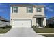 Two-story home with a double-car garage and neutral color palette at 2892 Waterlily Way, Poinciana, FL 34759