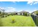 Spacious backyard with a grassy lawn and a black metal fence at 919 Braewood Dr, Clermont, FL 34715