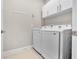 Convenient laundry room with washer and dryer, overhead cabinets, and tile flooring at 919 Braewood Dr, Clermont, FL 34715