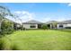 Large backyard with green lawn and view of neighboring homes at 919 Braewood Dr, Clermont, FL 34715