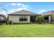 Landscaped backyard with spacious lawn and home exterior at 919 Braewood Dr, Clermont, FL 34715