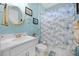 Charming bathroom with a shower/tub combo, white vanity, and coastal-themed decor at 919 Braewood Dr, Clermont, FL 34715
