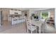 Bright dining area with white table and chairs, open to kitchen at 2888 Waterlily Way, Poinciana, FL 34759
