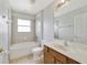 Clean bathroom with a tub, shower, and wood vanity at 2839 Boating Blvd, Kissimmee, FL 34746