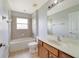 Clean bathroom with a tub, shower, and wood vanity at 2839 Boating Blvd, Kissimmee, FL 34746