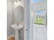 Convenient powder room with pedestal sink and view to backyard at 2839 Boating Blvd, Kissimmee, FL 34746