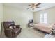 Bedroom with a comfy chair, bed, and a ceiling fan at 3090 Tioga Ter, Deltona, FL 32738