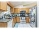 Kitchen with wood cabinets, granite countertops, and stainless steel appliances at 3090 Tioga Ter, Deltona, FL 32738