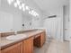 Bathroom with double sinks, light wood cabinets, and tile floors at 25013 Derby Dr, Sorrento, FL 32776