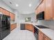 Kitchen with light wood cabinets, stainless steel appliances, and a breakfast bar at 25013 Derby Dr, Sorrento, FL 32776