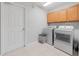 Laundry room with washer, dryer, cabinets, and tiled floor at 25013 Derby Dr, Sorrento, FL 32776